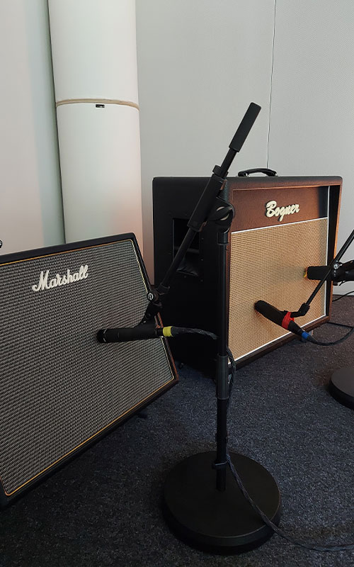 Im Aufnahmeraum des Studios sind nebeneinander ein Marshall- und ein Bogner-Gitarrenverstärker zur Aufnahme aufgebaut. Der Marshall ist mit einem Shure SM57 mikrofoniert, der Bogner-Amp mit einem Shure SM7B sowie mit einem Sennheiser MD421. Die Kabel sind von Vovox. Die Mikofone sind auf K&M-Stative mit Tellersockeln montiert. Im Hintergrund steht eine Hofa- Bassfalle in der Zimmerecke.